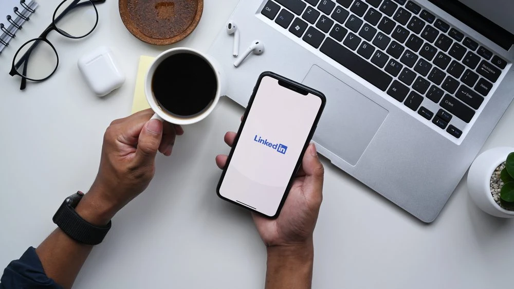 A real estate professional reviewing their LinkedIn profile on a laptop — LinkedIn strategy for real estate agents by C2 Communications.